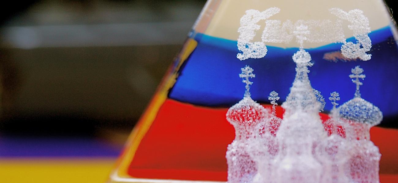 A glass triangle paperweight containing the Russian flag and St. Basil's cathedral. 