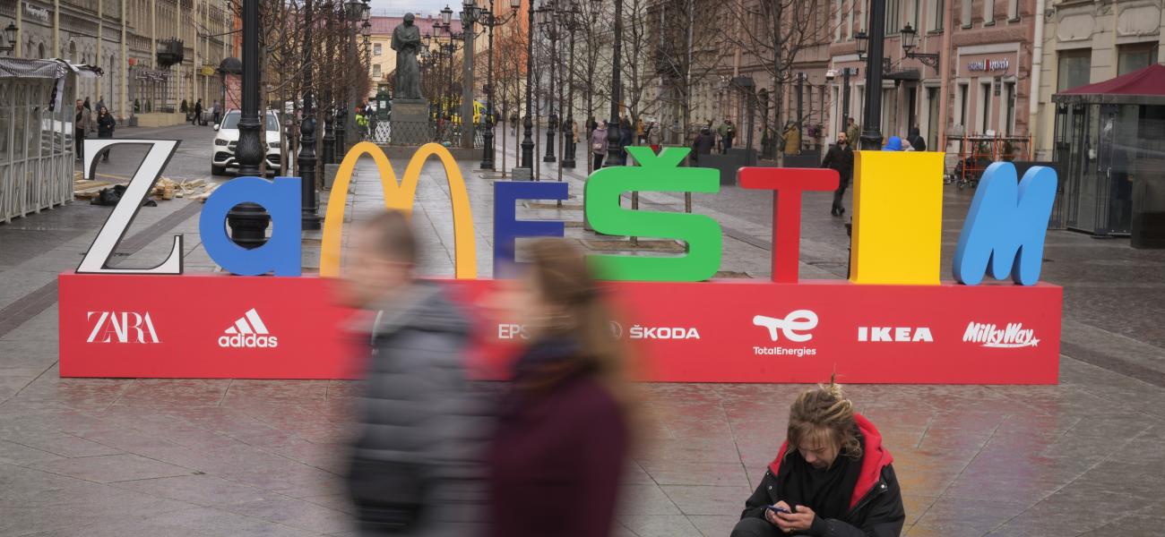 People walk past an installation 'Zamestim' (We will replace), assembled from the first letters of brands that left Russia in response to events in Ukraine, in St. Petersburg, Russia, Thursday, April 28, 2022. (AP Photo/Dmitri Lovetsky)