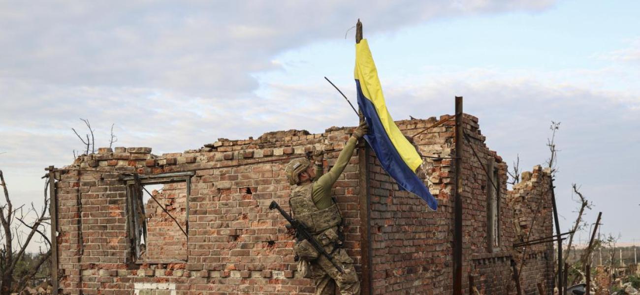 An assault unit commander from the 3rd Assault Brigade who goes by the call sign 'Fedia' raises the Ukrainian flag as a symbol of liberation of the frontline village of Andriivka, Donetsk region, Ukraine, Saturday, Sept. 16, 2023.
