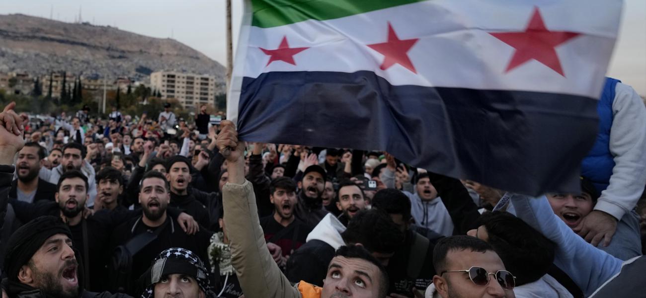 Syrian citizens wave the revolutionary flag and shout slogans, as they celebrate during the second day of the take over of the city by the insurgents in Damascus, Syria, Monday, Dec. 9, 2024. (AP Photo/Hussein Malla)