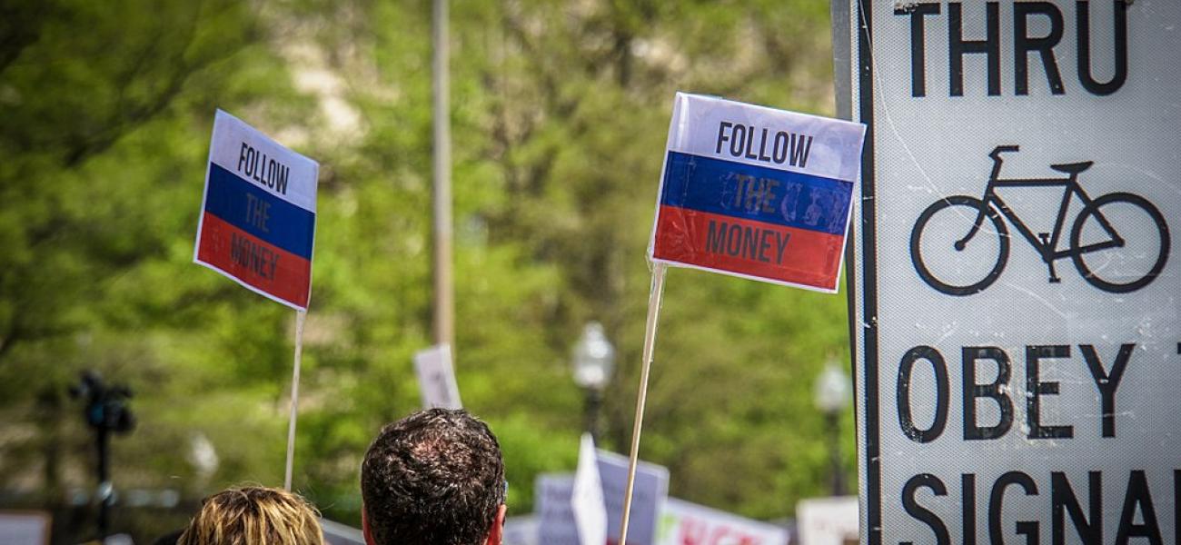 Russian flags that say "Follow the Money."