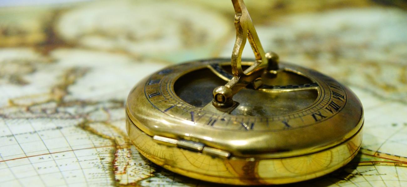 Compass setting a direction on an antique map.