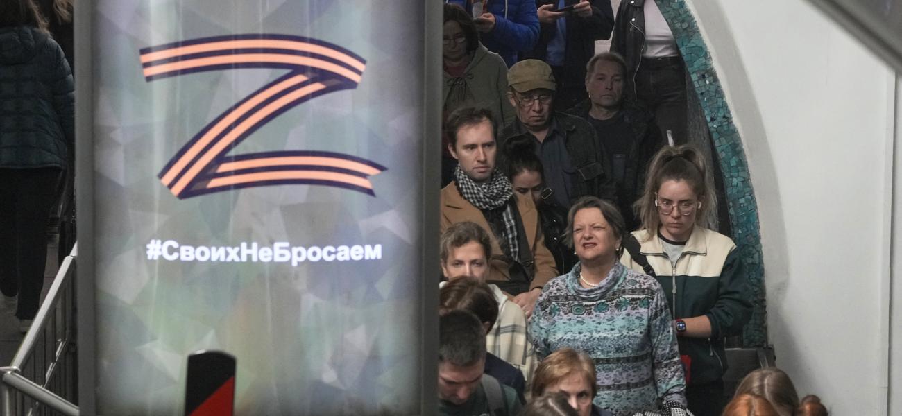 People go up the subway escalator past an advertising poster with letter Z, which has become a symbol of the Russian military and words 'We don't abandon ours' in St. Petersburg, Russia, Tuesday, Sept. 24, 2024. (AP Photo/Dmitri Lovetsky)