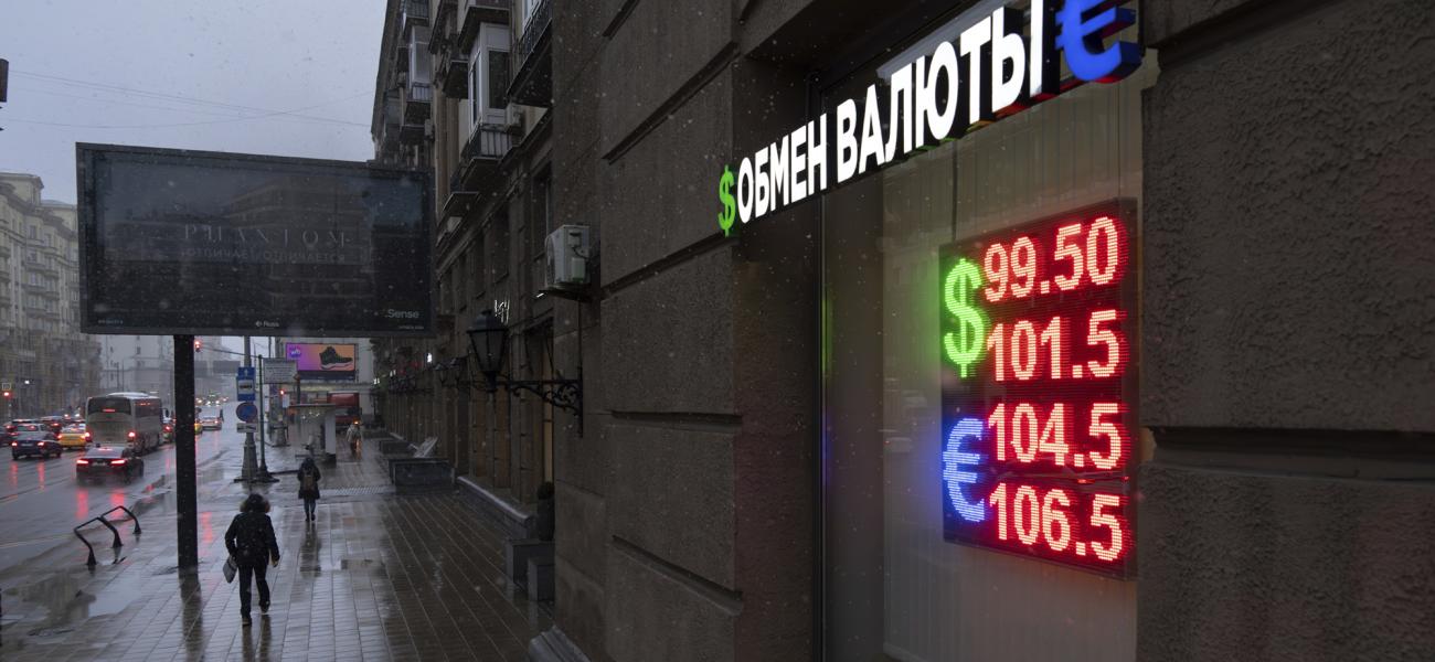 Pedestrians walk in a street near an exchange office sign showing the currency exchange rates of the Russian ruble, U.S. dollar, and euro in Moscow, Russia, Wednesday, Nov. 20, 2024. (AP Photo/Alexander Zemlianichenko)