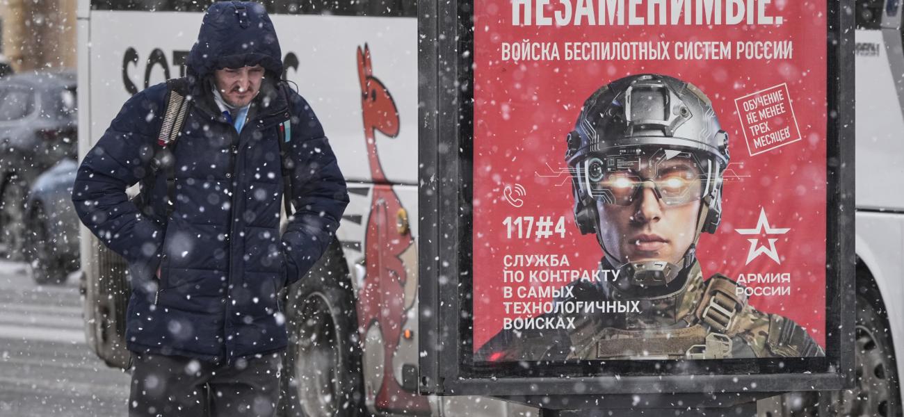 A man walks past a billboard promoting contract military service in the Russian army's unmanned systems units, in St. Petersburg, Russia, Wednesday, Feb. 4, 2026. (AP Photo/Dmitri Lovetsky)