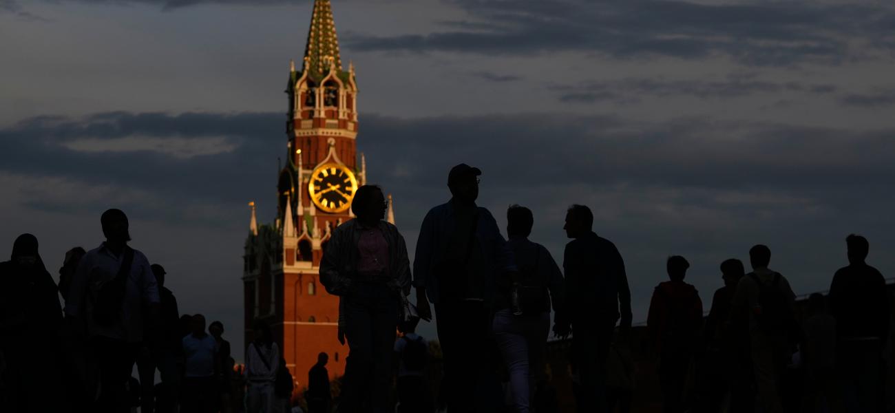 People walk through Red Square during sunset in Moscow, Monday, July 6, 2026, backdropped by the Spasskaya tower of the Kremlin. (AP Photo/Pavel Bednyakov)